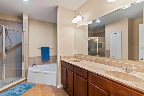 a bathroom with a granite countertop sink mirror and bathtub