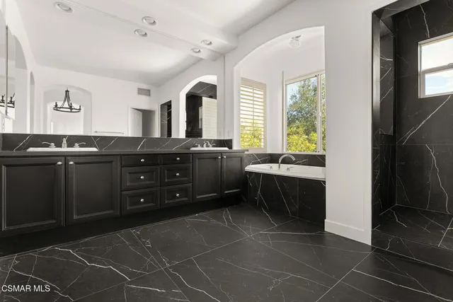 a bedroom with a bed and a mirror on dresser