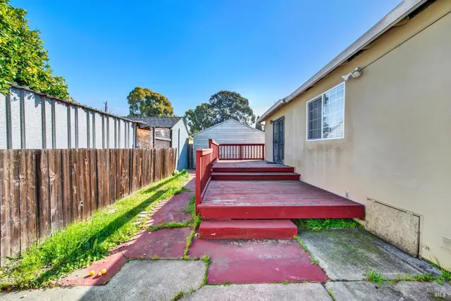 a view of small yard in front of a house with wooden fence