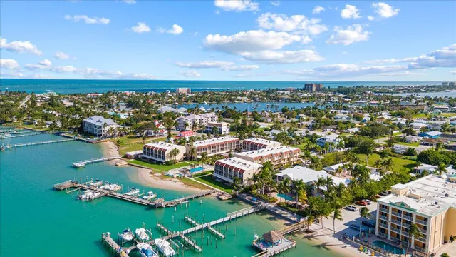 an aerial view of a city with lots of residential buildings ocean and mountain view in back