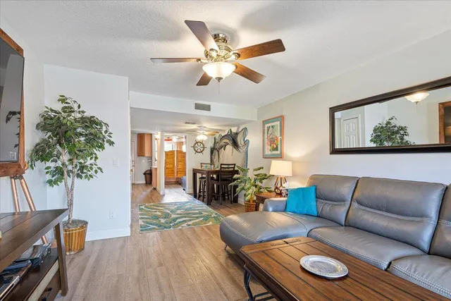 a living room with furniture a ceiling fan and a window
