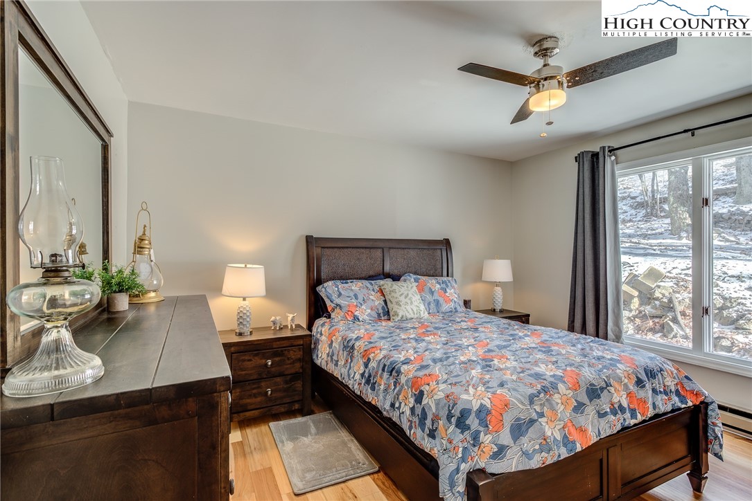 523 Pine Ridge Road Beech Mountain, NC 28604 - Photo 17 of 42 a bedroom with a large bed and a chandelier