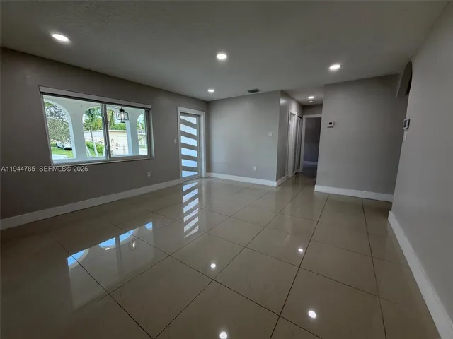 an empty room with closet and windows