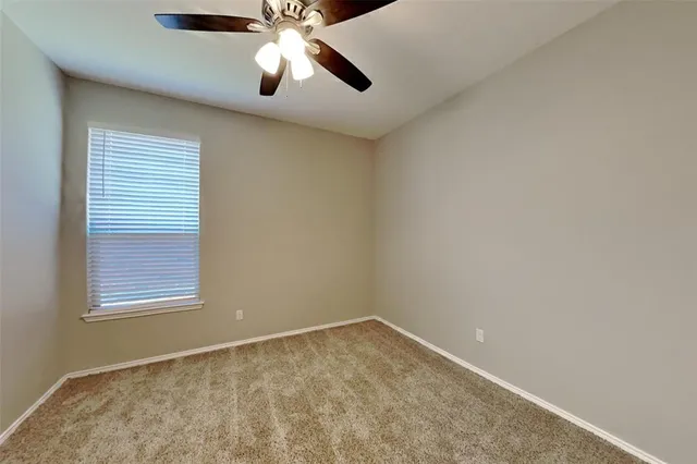 an empty room with closet and fan