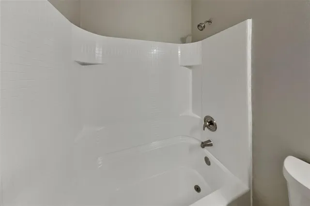 a bathroom with a granite countertop sink a toilet and a mirror