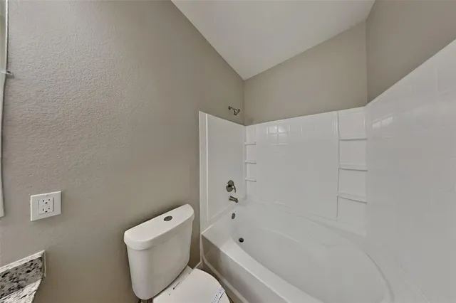 an empty room with window and ceiling fan