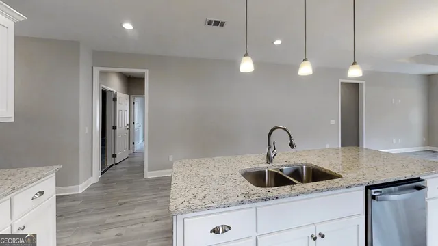 a kitchen with stainless steel appliances granite countertop a sink a stove a microwave a center island and cabinets