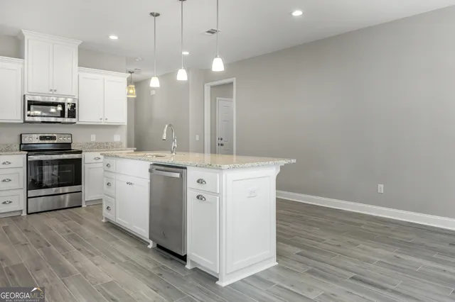 an open kitchen with a refrigerator and microwave