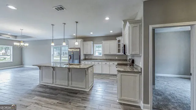 a kitchen with sink cabinets and chandelier