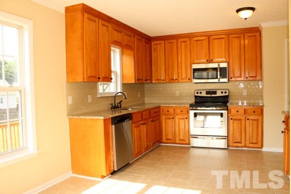 1504 Harvey Johnson Road Raleigh, NC 27603 - Photo 17 of 22 a kitchen with stainless steel appliances a stove sink and cabinets