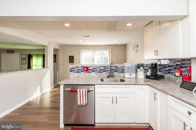 a kitchen with kitchen island granite countertop a sink and cabinets