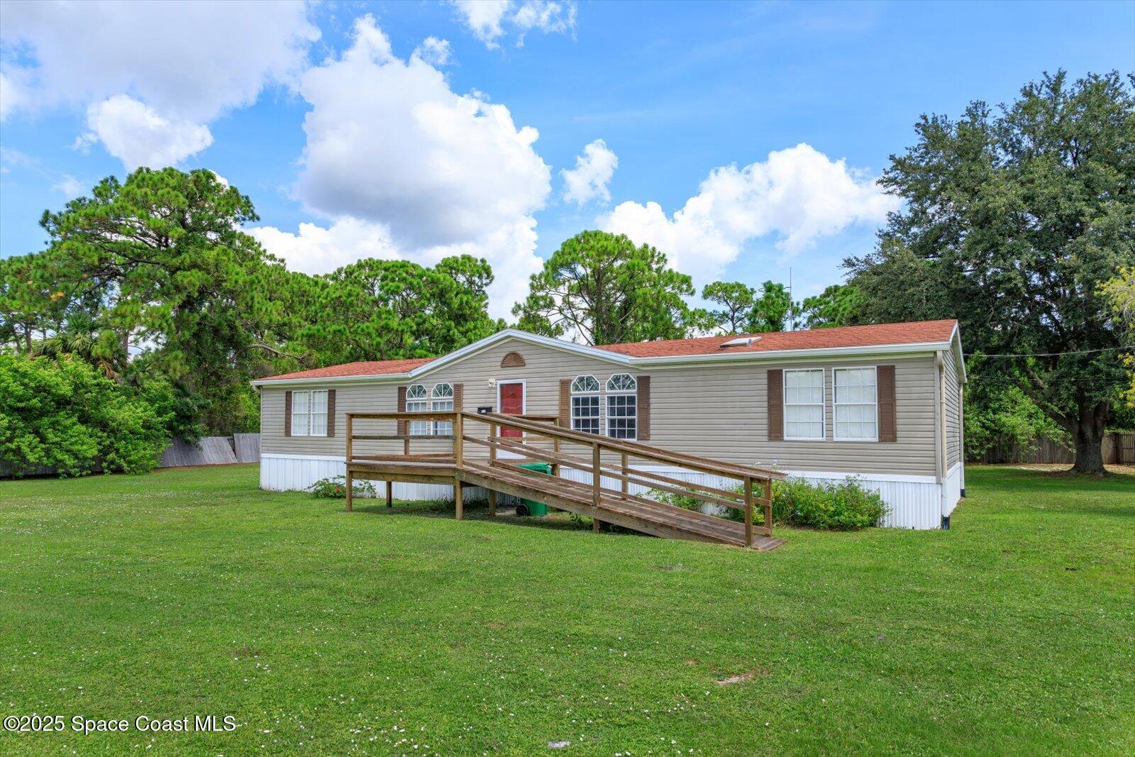 616 Camp Road Cocoa, FL 32927 - Photo 1 of 25 a front view of house with yard and trees in the background