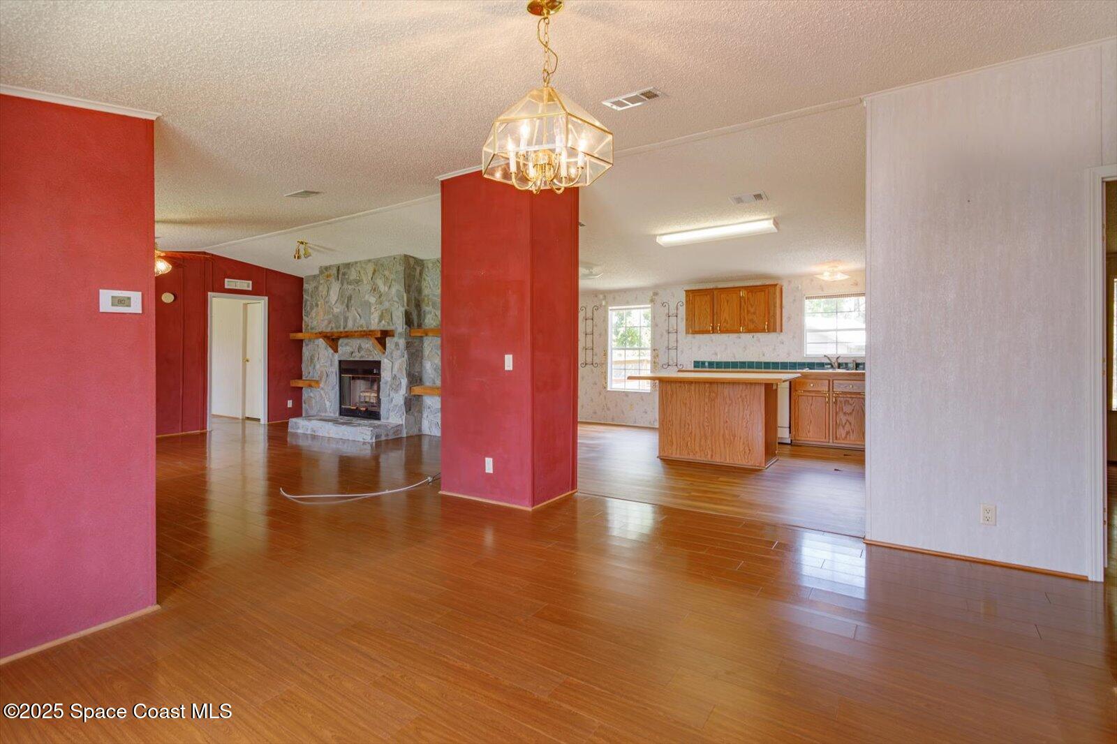 616 Camp Road Cocoa, FL 32927 - Photo 13 of 25 a view of a room with wooden floor a kitchen view and a chandelier