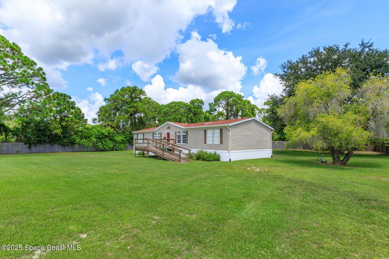 616 Camp Road Cocoa, FL 32927 - Photo 2 of 25 a view of a tiny house with a big yard and large trees