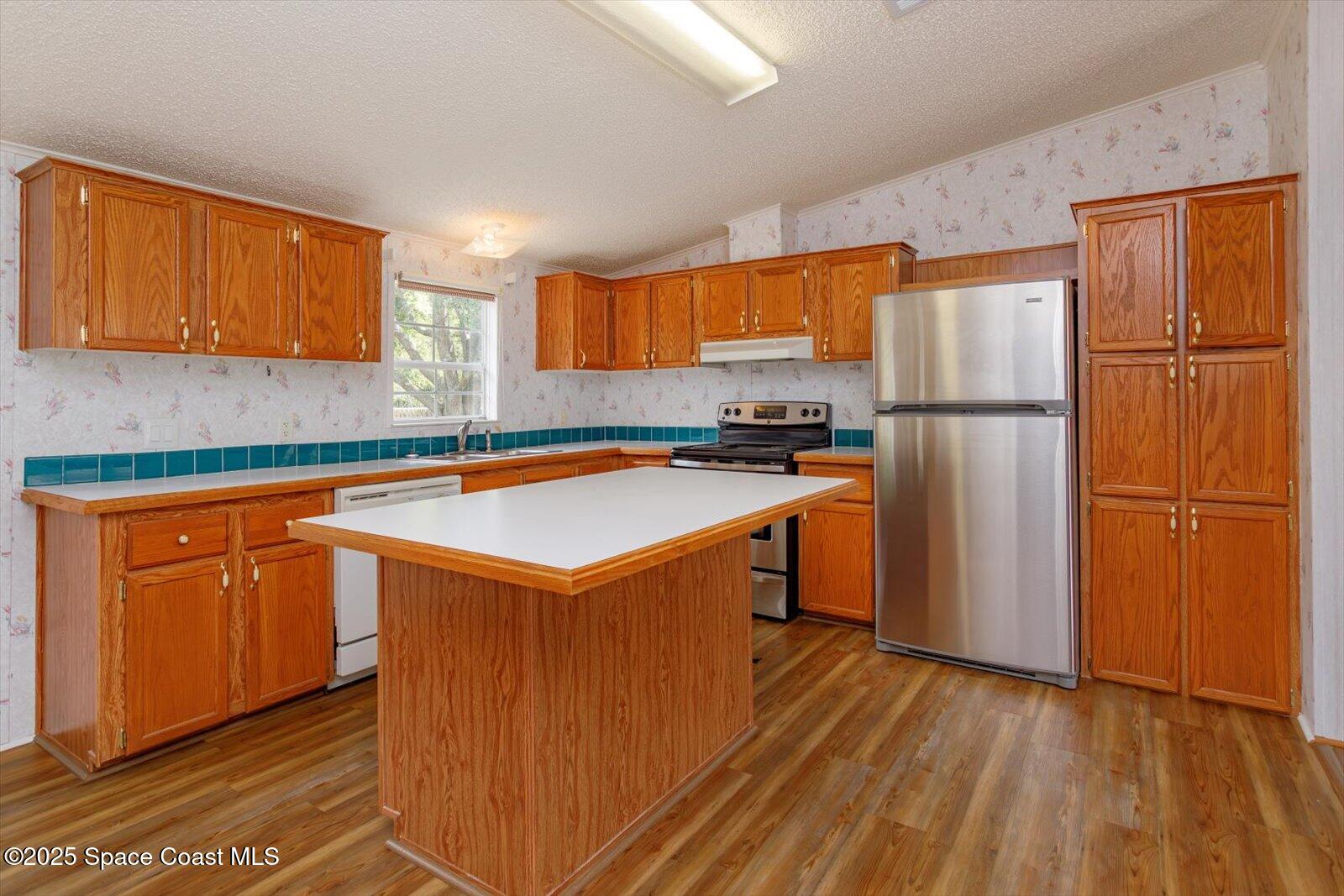 616 Camp Road Cocoa, FL 32927 - Photo 7 of 25 a kitchen with a refrigerator sink and cabinets
