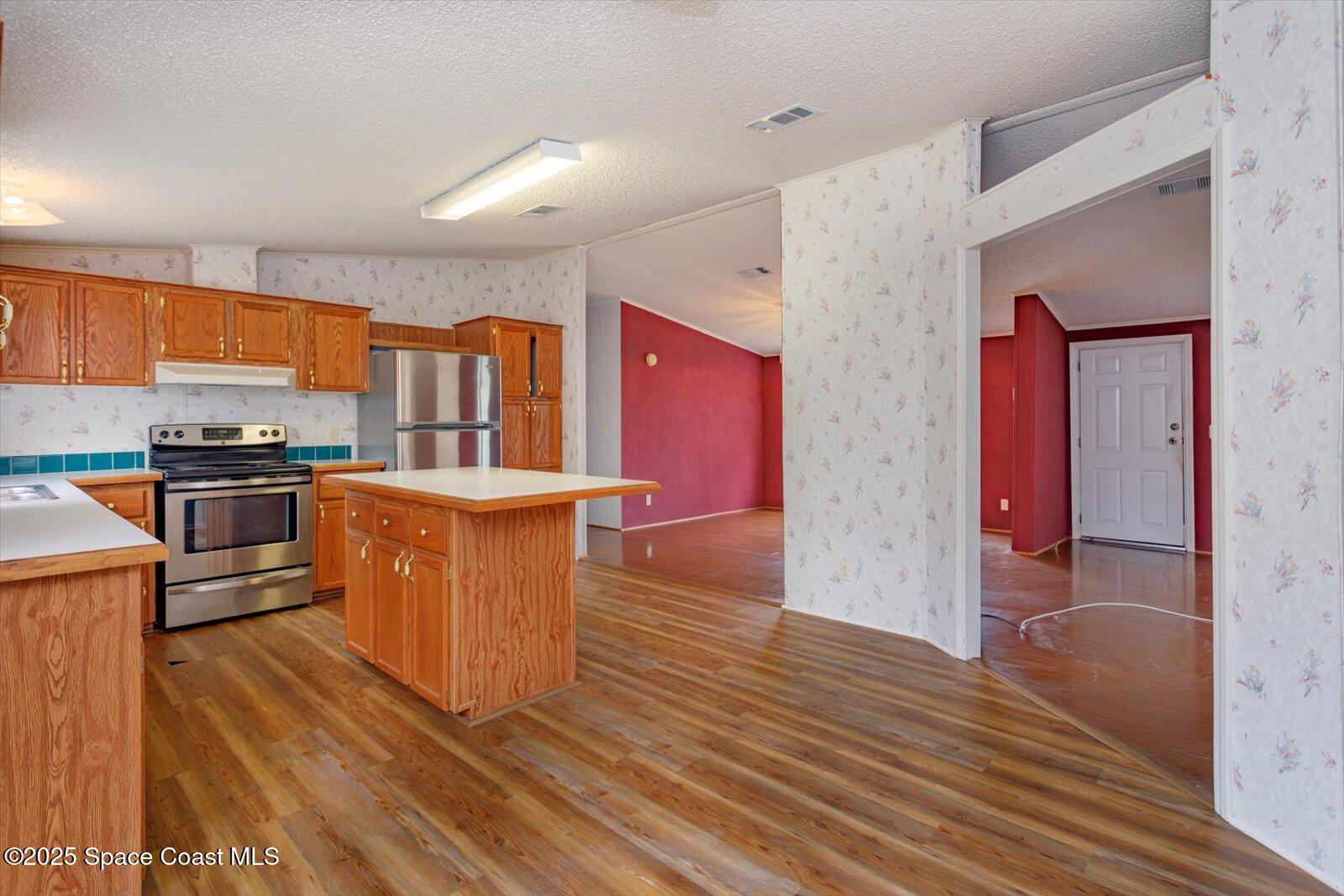 616 Camp Road Cocoa, FL 32927 - Photo 10 of 25 a kitchen with stainless steel appliances wooden floors and wooden cabinets