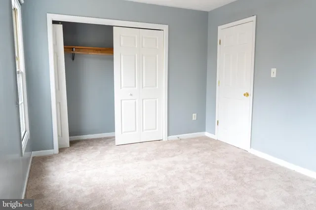 an empty room with closet and a bathroom