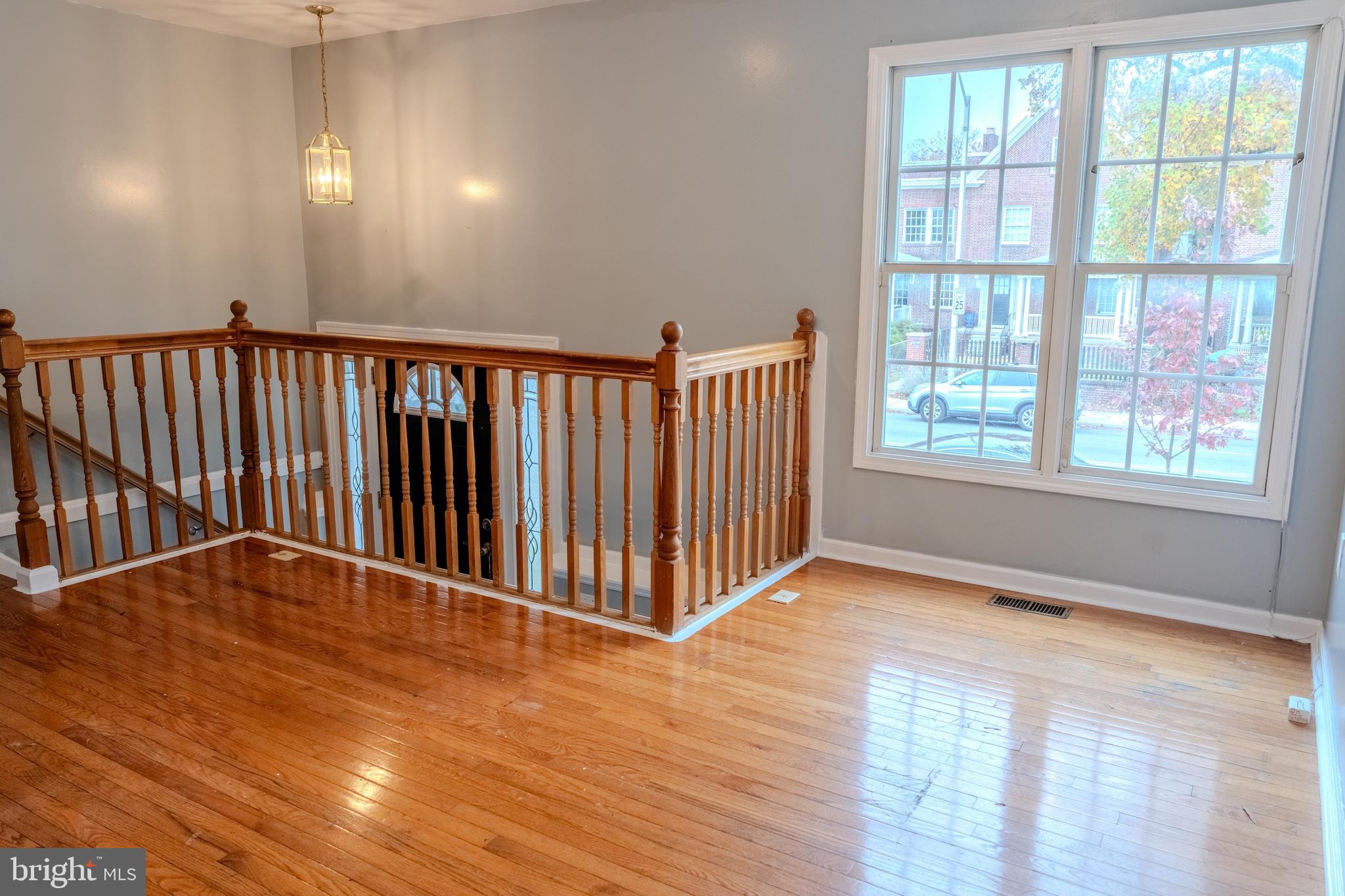 3731 Greenmount Avenue Baltimore, MD 21218 - Photo 3 of 23 a view of a hallway with wooden floor and stairs