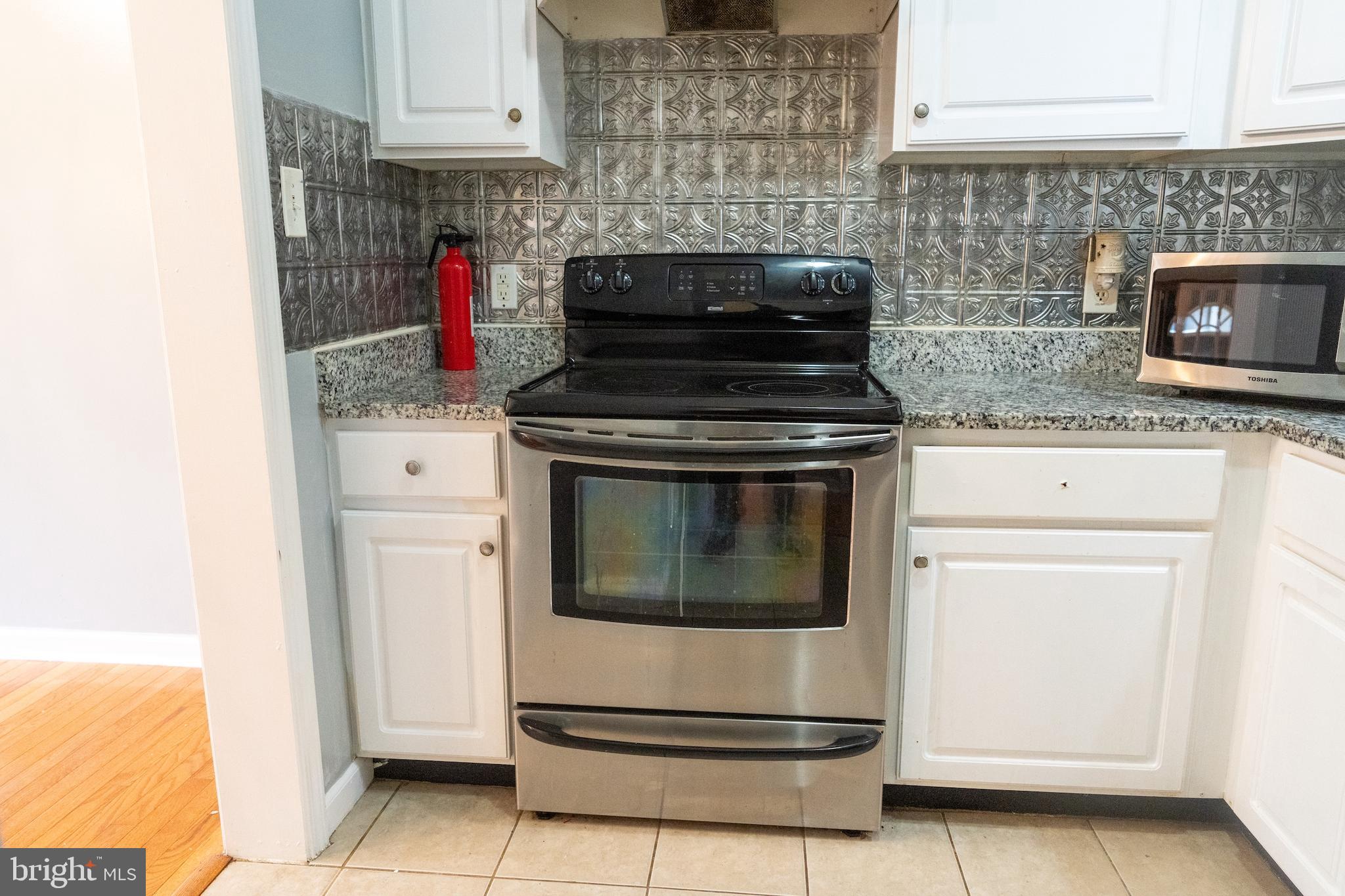 3731 Greenmount Avenue Baltimore, MD 21218 - Photo 6 of 23 a stove top oven sitting inside of a kitchen