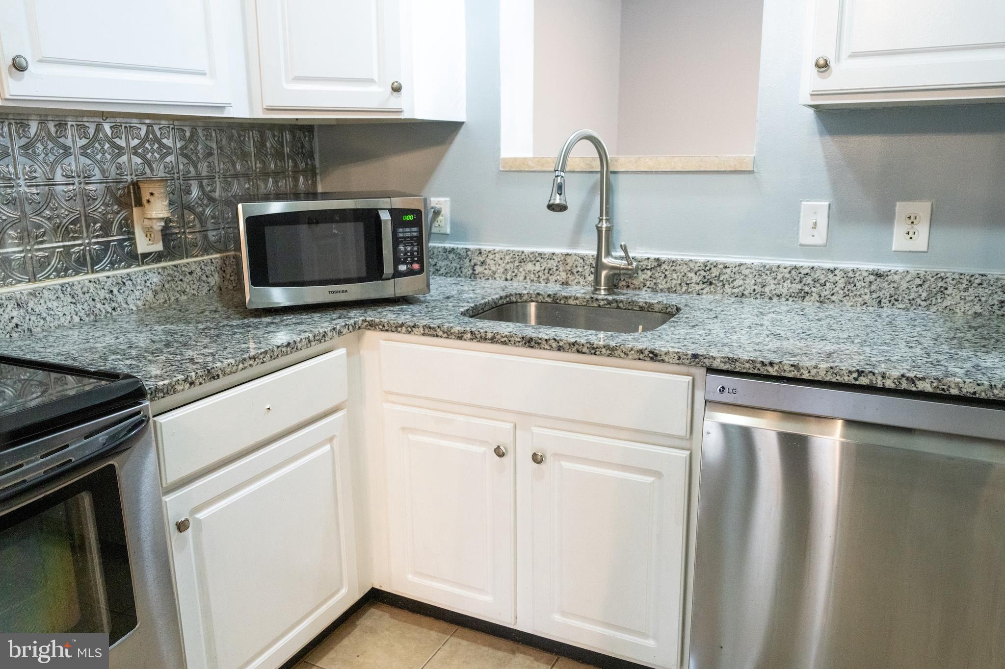 3731 Greenmount Avenue Baltimore, MD 21218 - Photo 7 of 23 a kitchen with granite countertop cabinets stainless steel appliances and sink
