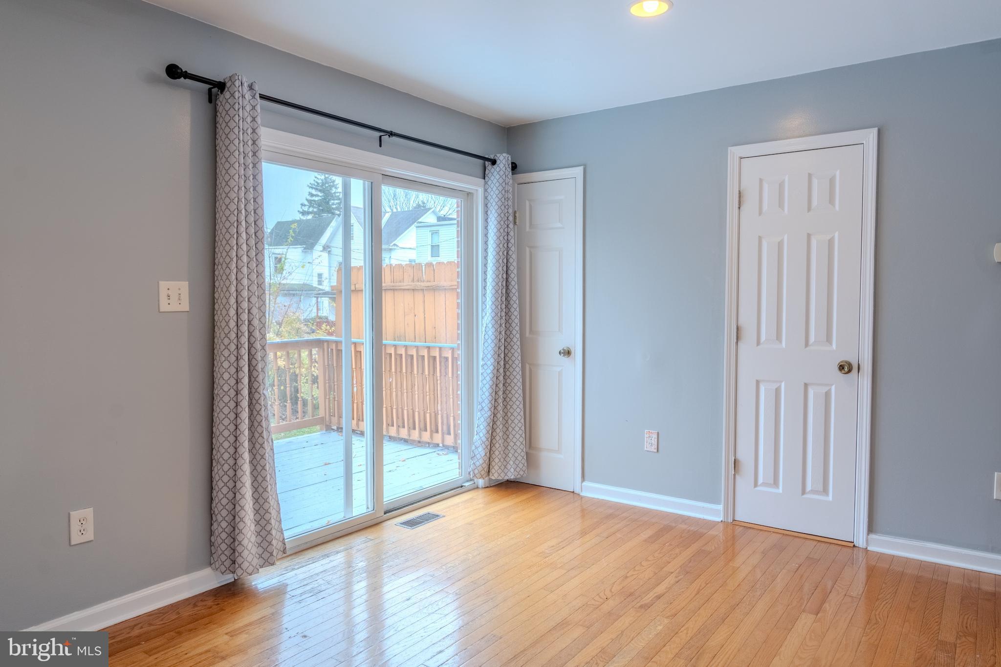 3731 Greenmount Avenue Baltimore, MD 21218 - Photo 9 of 23 a view of an empty room with wooden floor and a window