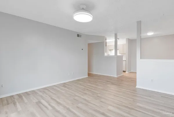 a view of empty room with wooden floor
