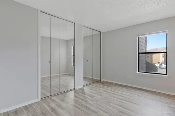 an empty room with windows and closet