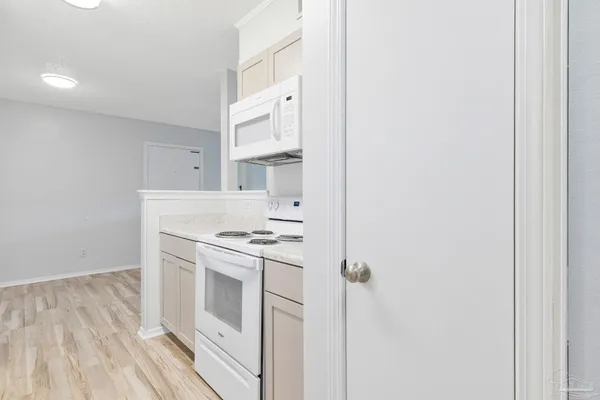 a kitchen with a stove and white cabinets