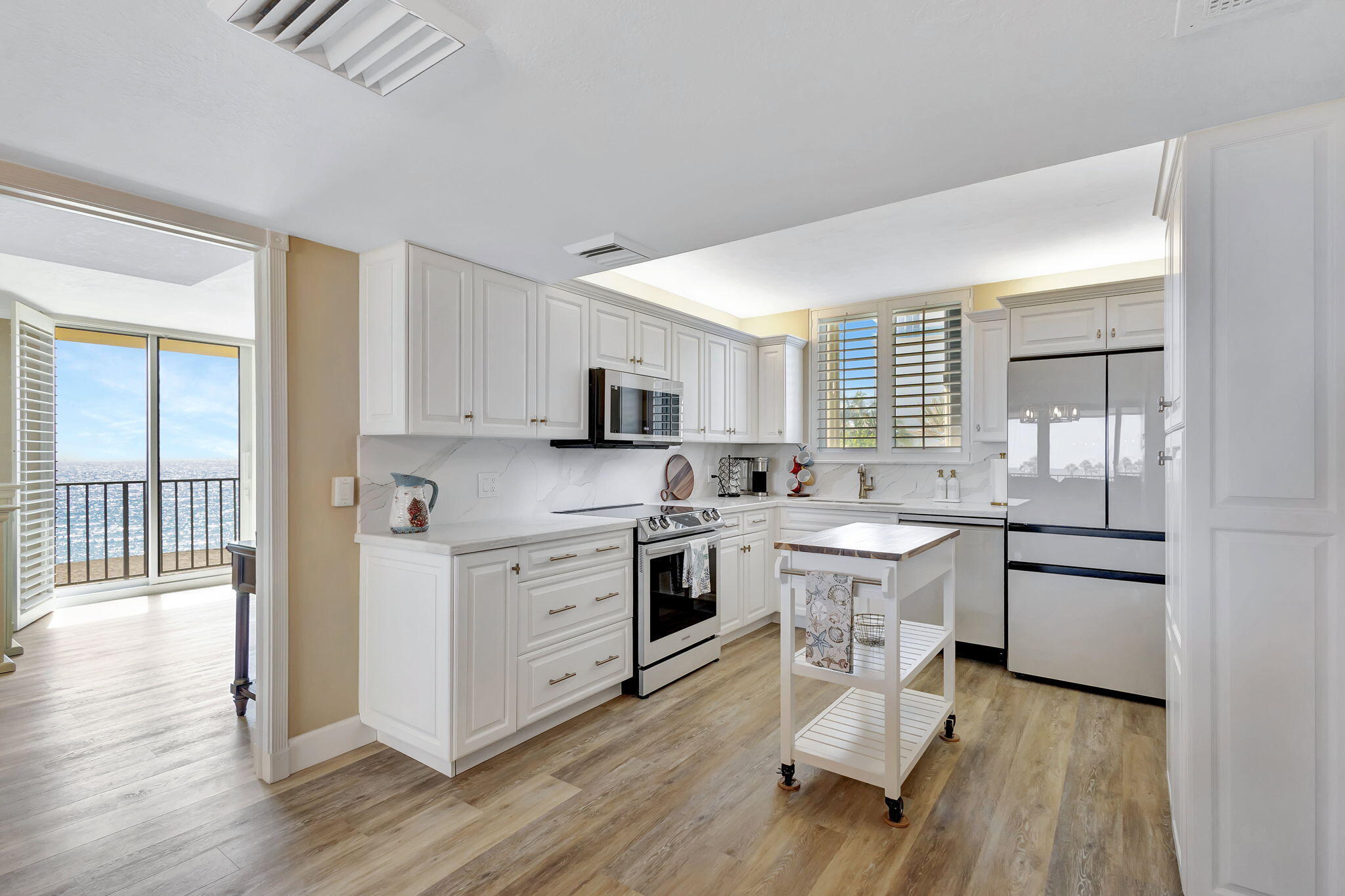 100 Ocean Trail Way, Unit 301 Jupiter, FL 33477 - Photo 2 of 67 a open kitchen with white cabinets and white appliances