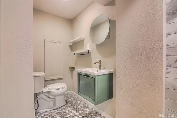 a bathroom with a sink a toilet and mirror