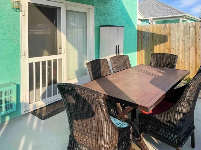 a view of a patio with table and chairs with wooden floor and fence