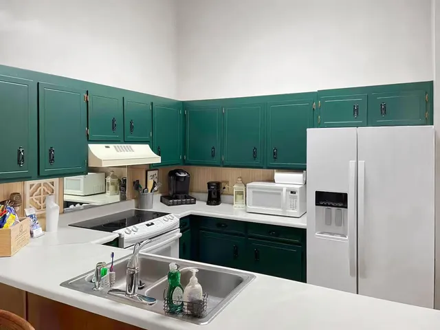 a kitchen with kitchen island a sink a stove and a refrigerator