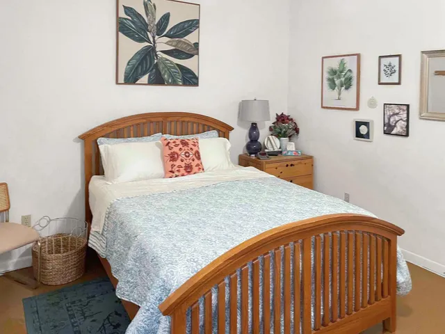 a bedroom with a bed and painting on the wall