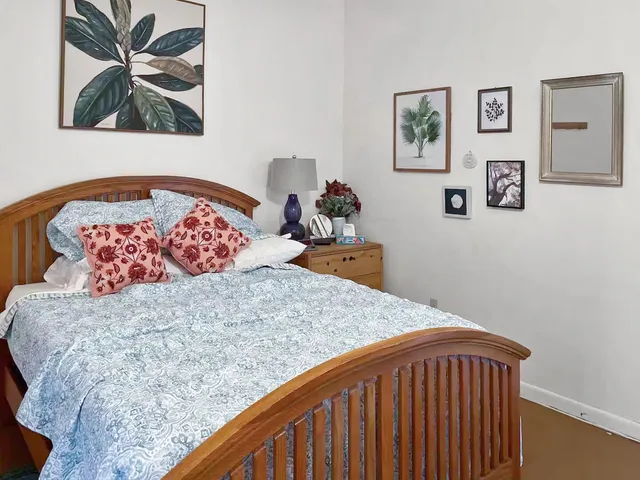 a bed sitting in a bedroom and painting on the wall