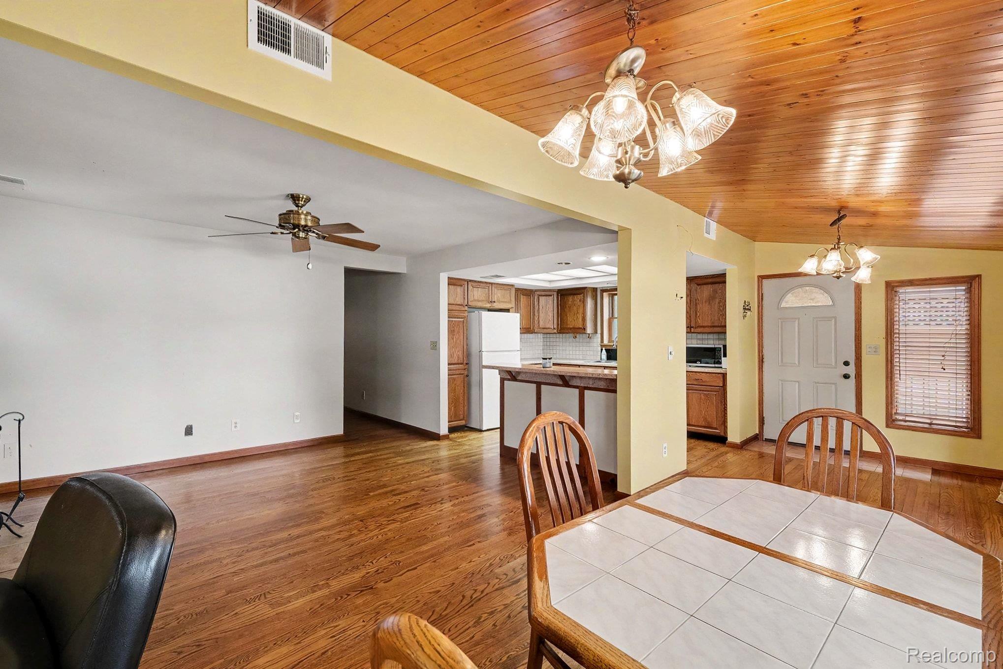 16059 Murray Road Byron, MI 48418 - Photo 9 of 32 Spacious interior featuring wood-finish flooring, a paneled wood ceiling, and a ceiling fan