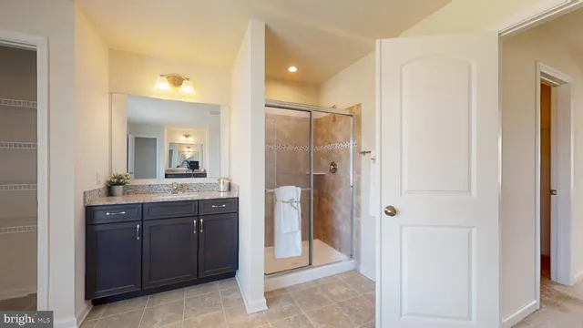 a bathroom with a granite countertop sink mirror and shower
