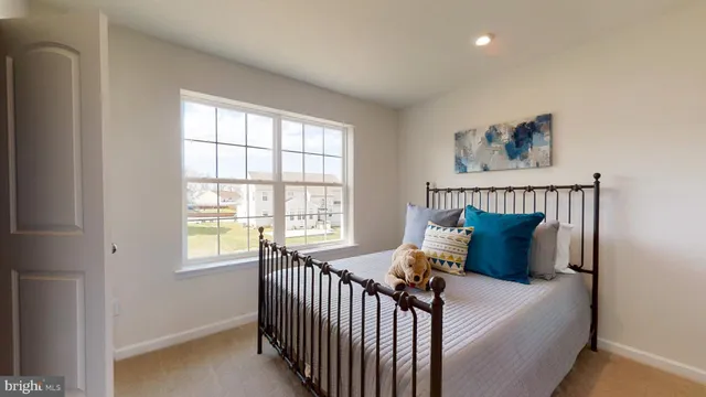 a bed sitting in a bedroom next to a window