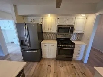 a kitchen with a refrigerator stove and wooden cabinets