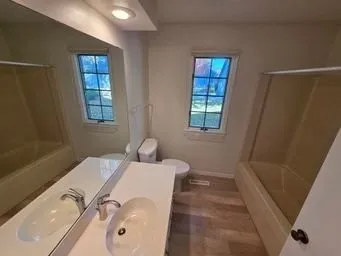 a bathroom with a tub sink and mirror