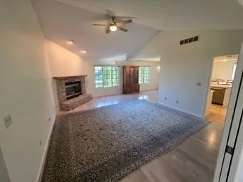 an empty room with windows and fireplace