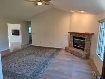an empty room with windows and fireplace
