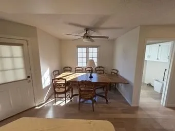 a view of a a dining room with furniture window and wooden floor