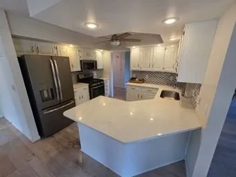 a kitchen with stainless steel appliances a stove a refrigerator a sink and a refrigerator