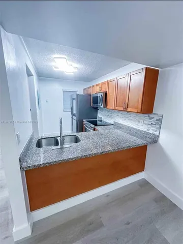 a view of kitchen with granite countertop sink and granite counter tops