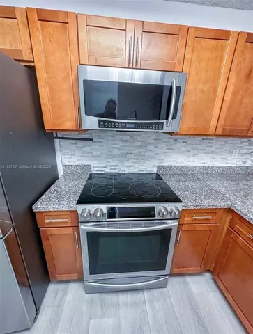 a stove top oven sitting inside of a kitchen