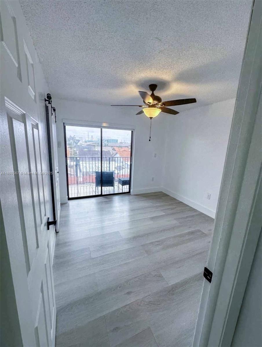 2301 West 60th Street, Unit A211 Hialeah, FL 33016 - Photo 20 of 29 an empty room with wooden floor and windows