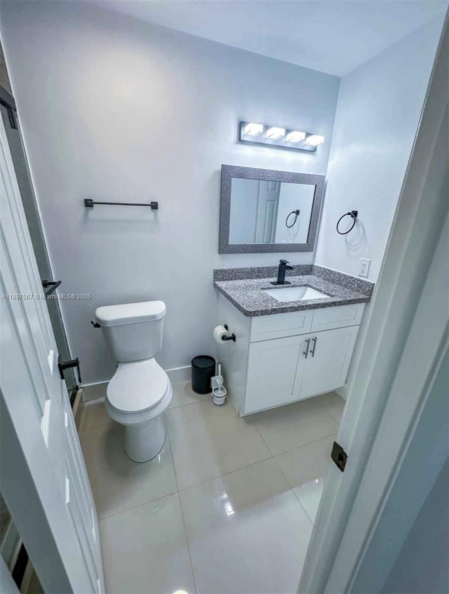 2301 West 60th Street, Unit A211 Hialeah, FL 33016 - Photo 22 of 29 a bathroom with a sink a toilet and a mirror