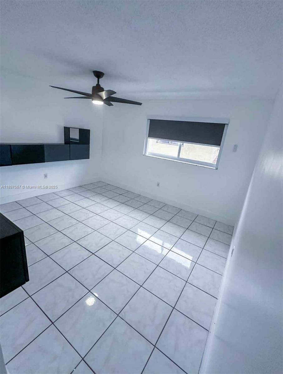 2301 West 60th Street, Unit A211 Hialeah, FL 33016 - Photo 26 of 29 a view of a livingroom with a ceiling fan and window