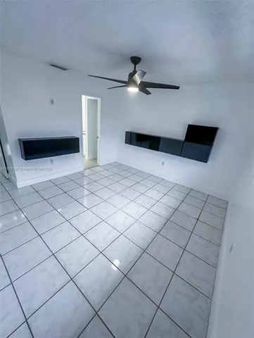 a view of a livingroom with a ceiling fan and window