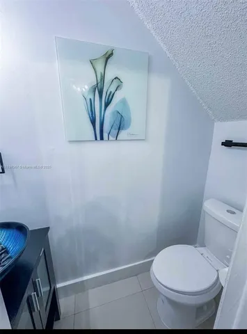a white toilet sitting next to a shower